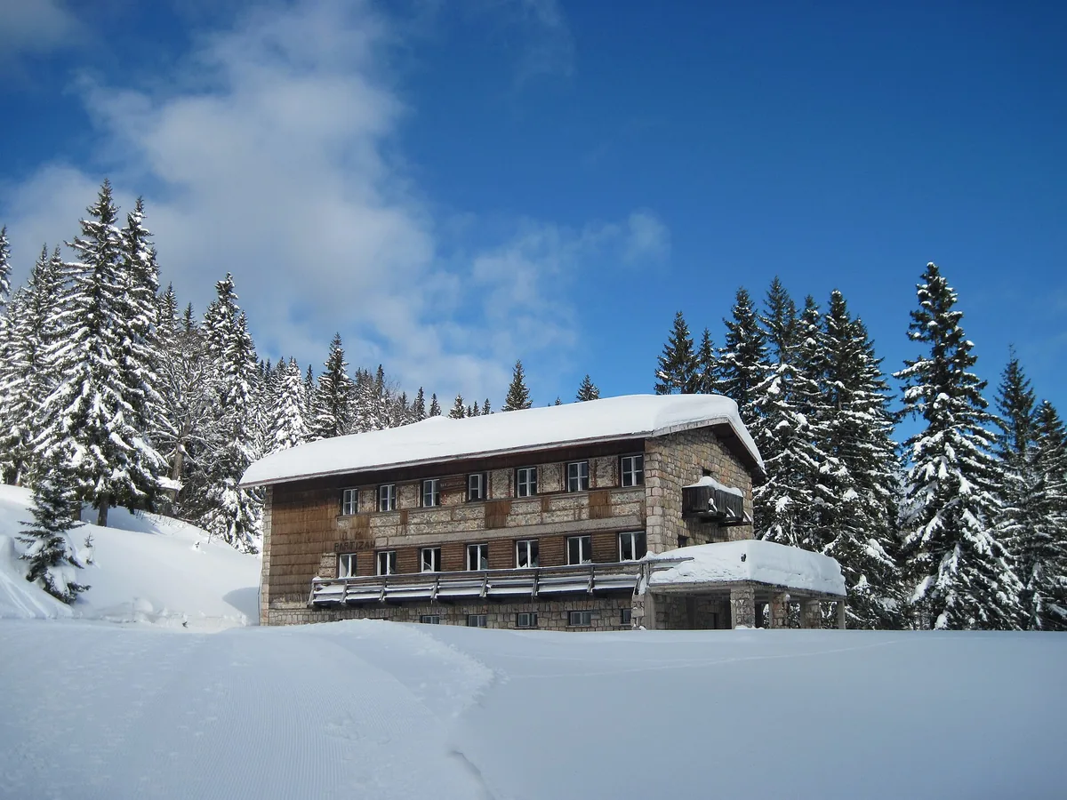 A snow-covered chalet and forest on Jahorina