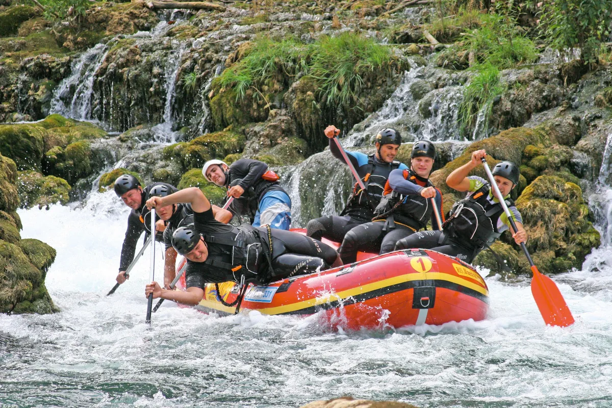 Rafters paddling through a rapid on the Una River